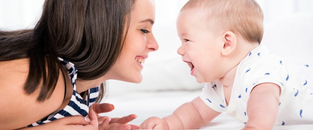 Baby und Mama lachen sich an
