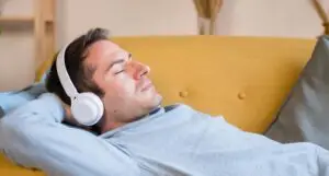 Mann auf Sofa bei einer Darmhypnose Audiositzung