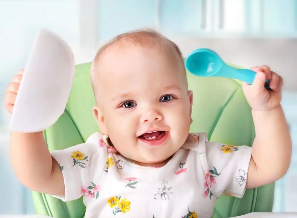Baby freut sich über Löffel und Beikost Schälchen
