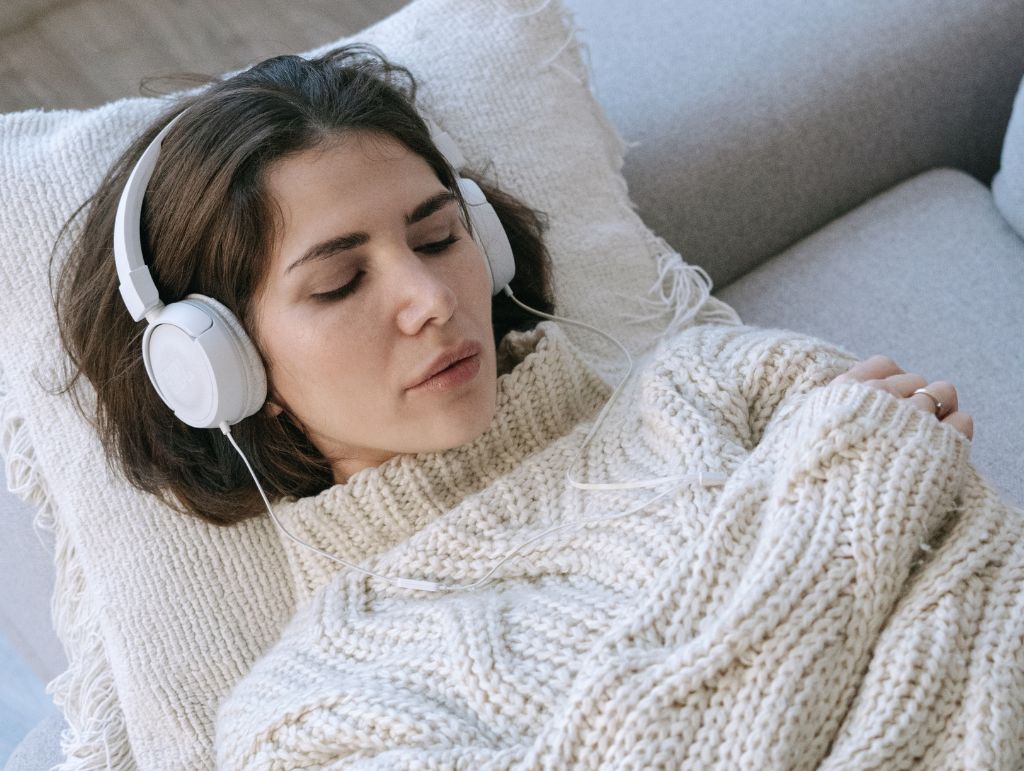 Darmhypnose im Alltag – Frau hört entspannende Audioübung mit Kopfhörern