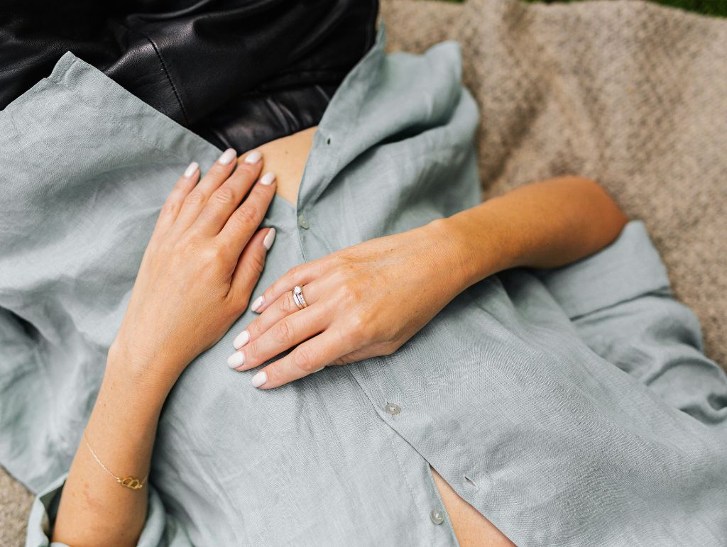 Frau liegt entspannt und legt die Hände auf den Bauch – Symbol für ruhige Verdauung und Reizdarm-Beschwerden